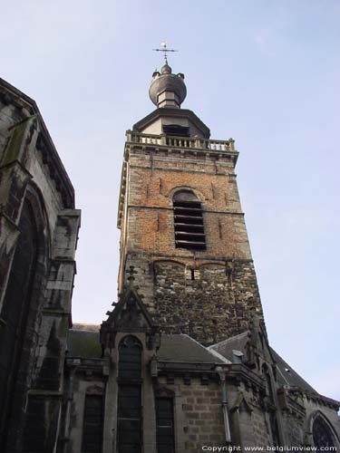 Collgiale Saint-Ursmer  / Sint-Ursmarus kapittelkerk BINCHE / BELGI De toren uit bestaat uit drie delen. De basis werd uitgevoerd in plaatselijke zandsteen en bevat een gotisch raam van de tweede helft van de 15de eeuw. De verdieping erboven werd opgebouwd rond 1583 in baksteen en bevat vier galmgaten. Het bovenste gedeel