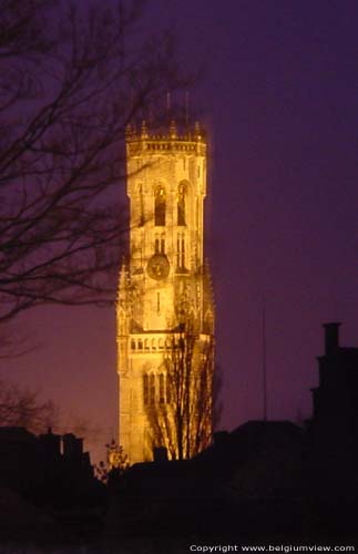 Belfort van Brugge en hallen (halletoren) BRUGGE / BELGI 's Nachts is de verlichte torenspits van ver zichtbaar.