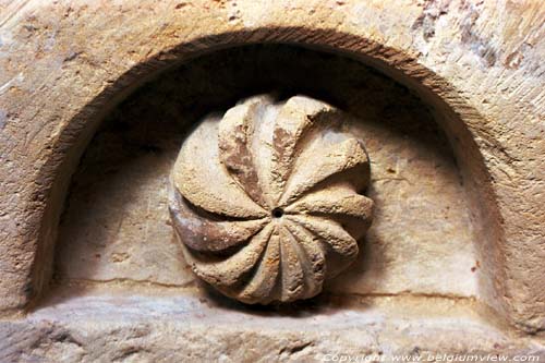 Sint-Amanduskerk van Wezeren WALSHOUTEM / LANDEN foto In de bovenste laag van het altaar zijn elf nissen aangebracht voorzien van rozetten.  Hier een opengebarsten bol als motief.