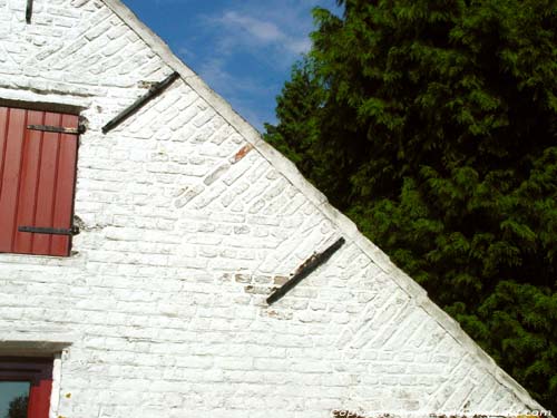 Kleine hoeve met zwaluwstaarten in Tillegem park SINT-ANDRIES in BRUGGE / BELGI De gezaagde rand in het patroon van de baksteen heet zwaluwstaartverband.