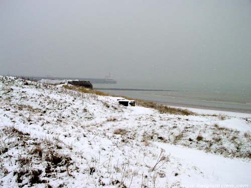 Besneeuwde duinen en strand OOSTENDE foto Zicht vanuit de duinen op het ooststaketsel