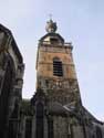 Collgiale Saint-Ursmer  / Sint-Ursmarus kapittelkerk BINCHE foto: De toren uit bestaat uit drie delen. De basis werd uitgevoerd in plaatselijke zandsteen en bevat een gotisch raam van de tweede helft van de 15de eeuw. De verdieping erboven werd opgebouwd rond 1583 in baksteen en bevat vier galmgaten. Het bovenste gedeel