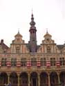Borse van Amsterdam AALST / BELGIË: Bijzonder zijn de paren van klokvormige geveltoppen, met de torenspits in het midden. Let ook op de eenvoudige kruiskozijnen op de tussenverdieping, waarvan de horizontale as doorloopt in het lijstwerk op de muur