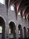 Sint-Pieterskerk KORTESSEM foto: In het middenschip worden de 15de eeuwse laatgotische gewelven opgevangen door massieve vierkante pijlers. In de arcadebogen werden mergelstenen en ook enkele romeinse dakpannen verwerkt. 