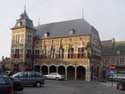 Stadhuis ('s Grevenhuis) BORGLOON foto: Overzicht van het Maasrenaissance stadhuis, met de voorgebouwde toren, opvallende kruiskozijnen en de galerij aan de zijde van de Markt.