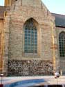 Sint-Pietersabdijkerk LO-RENINGE / BELGI: Muur met onderaan ijzerzandsteen en daarboven een spitsboogvenster.