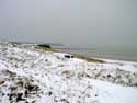 Besneeuwde duinen en strand OOSTENDE / BELGI: Zicht vanuit de duinen op het ooststaketsel